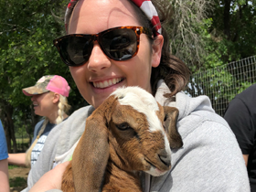 Employee Emily hugging goat named Flower