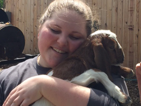 Team member Tyleigh hugging goat named Flower